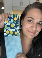 Woman holding a blue towel with lemon pattern in a kitchen setting