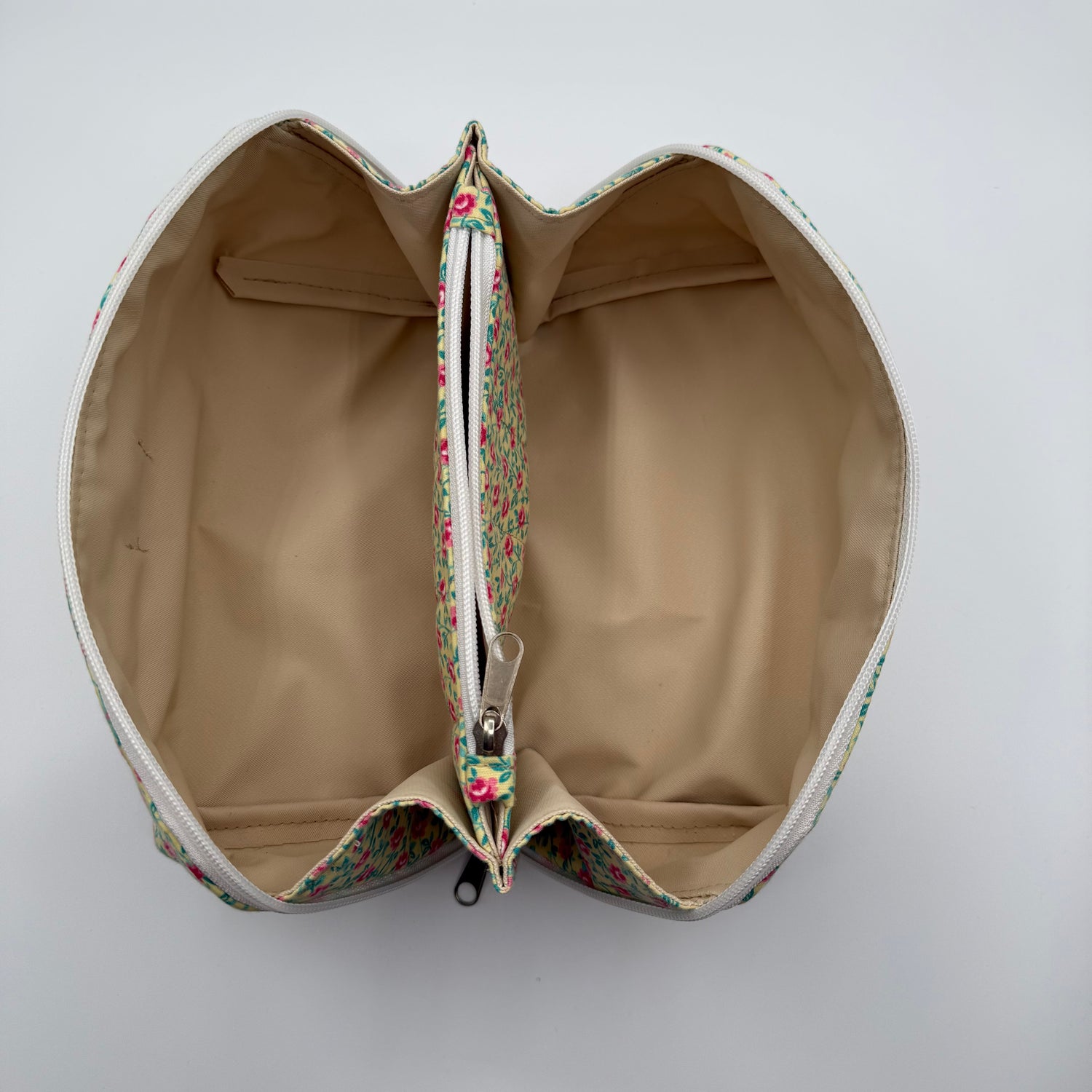Heart-shaped pouch with floral zipper on a white background