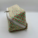 Floral-patterned zippered pouch on a gray background