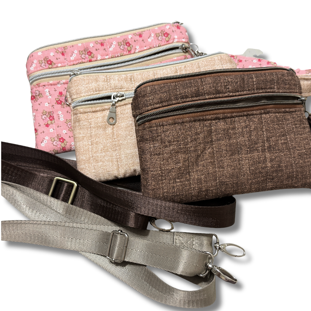 Four small zippered pouches or crossbody bags in different colors and fabrics are arranged on a white background, including pink floral, beige, brown textured, and gray/taupe options, with straps visible.