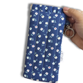 Blue White Daisies quilted Flexi Frame Pouch clipped to a black tote bag handle, holding sunglasses