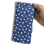 Blue White Daisies quilted Flexi Frame Pouch clipped to a black tote bag handle, holding sunglasses