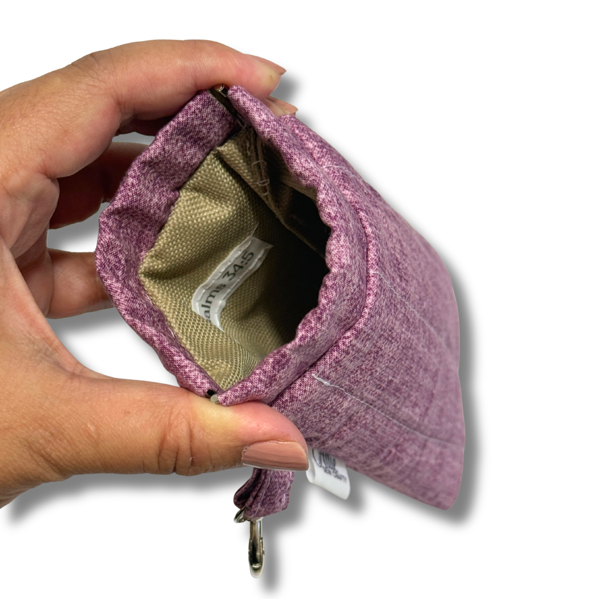 Hand opening a plum pouch showing tan lining and tag with Psalms 34:5 label in a white background