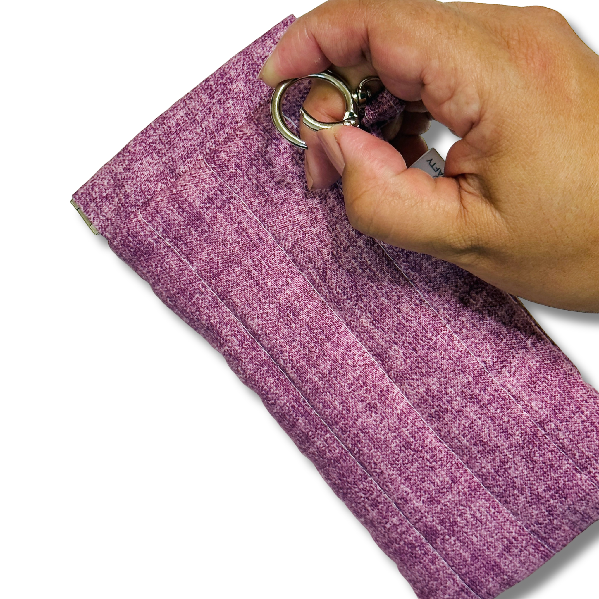 Hand pushing a round swivel hook open against the plum pouch on a white background