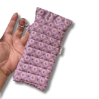 A hand holding a small quilted fabric pouch with a lavender floral print and a silver key ring attachment, shown against a plain white background.