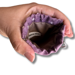 hand opening a snap on pouch showing the tan lining and tag that says Psalms 34:5