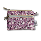 A small fabric zip pouch with a purple floral pattern, featuring two silver zippers, a metal key ring, and a white brand tag that reads 'Allie Sew Crafty'.