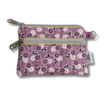 A small fabric zip pouch with a purple floral pattern, featuring two silver zippers, a metal key ring, and a white brand tag that reads 'Allie Sew Crafty'.