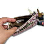 hand opening a wallet showing tan lining with a tag that says Psalms 34:5 and keys with a white background