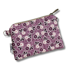 A small zippered pouch with a purple floral and floral pattern, featuring a wrist strap and metal hardware, shown on a white background.