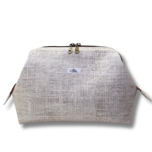 Textured beige pouch with a brand label on a white background