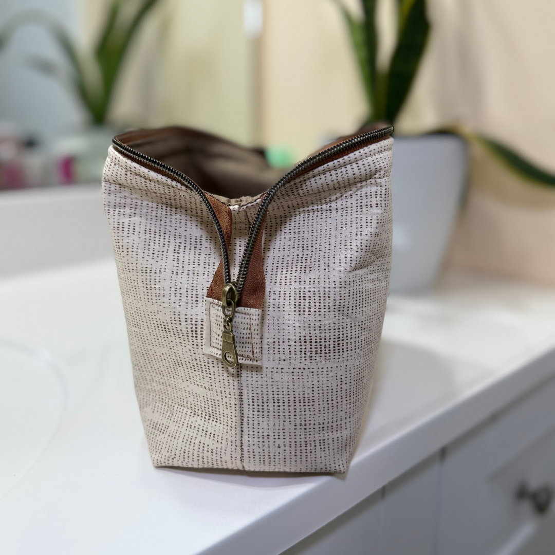 Textured fabric bag with a zipper on a white surface