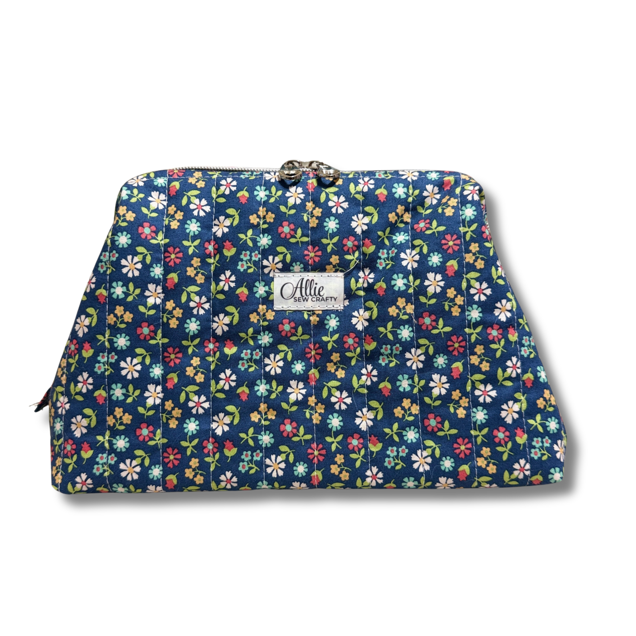 A quilted cosmetic pouch by Allie Sew Crafty featuring a navy blue background with a colorful floral pattern of pink, yellow, white, and green flowers, complete with a silver-tone metal clasp closure at the top.
