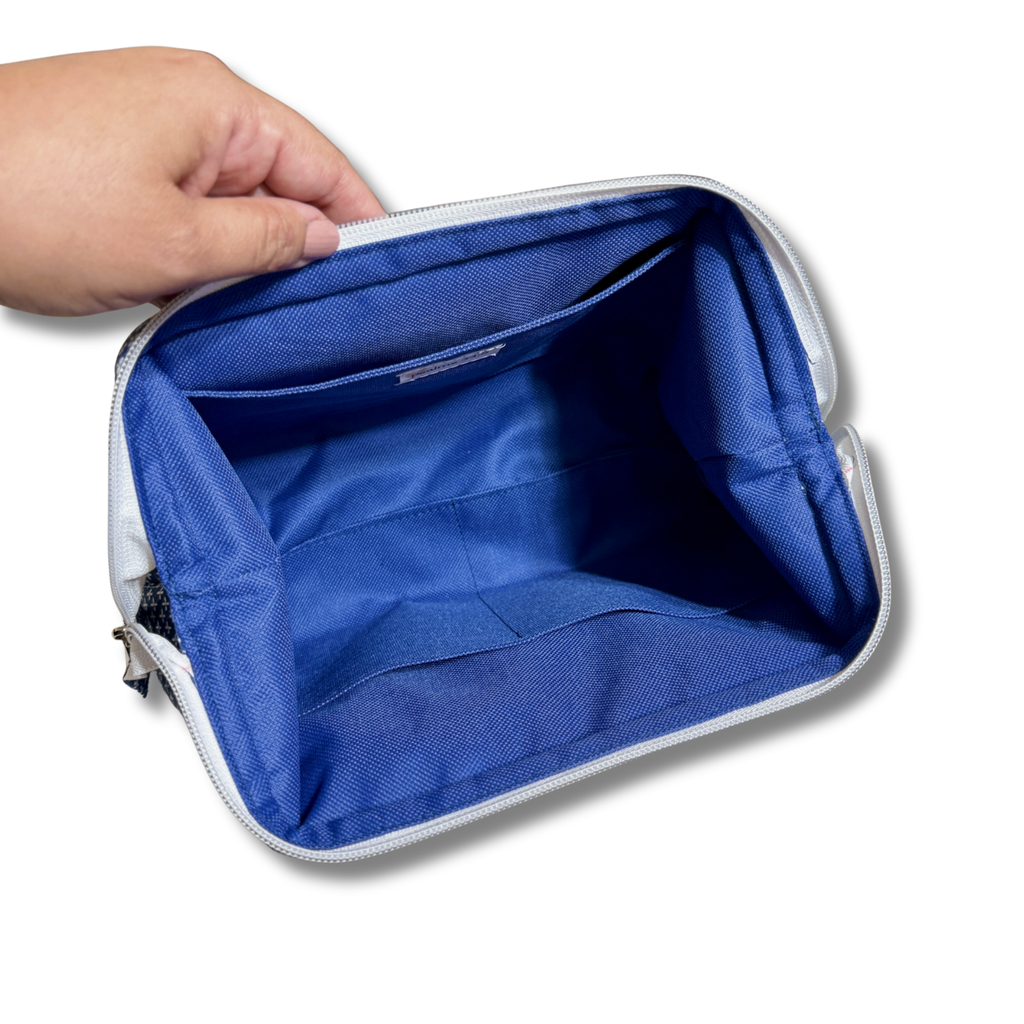 A hand holding open a rectangular zippered pouch or organizer, showing a bright blue interior lining with multiple pockets and a white zipper.