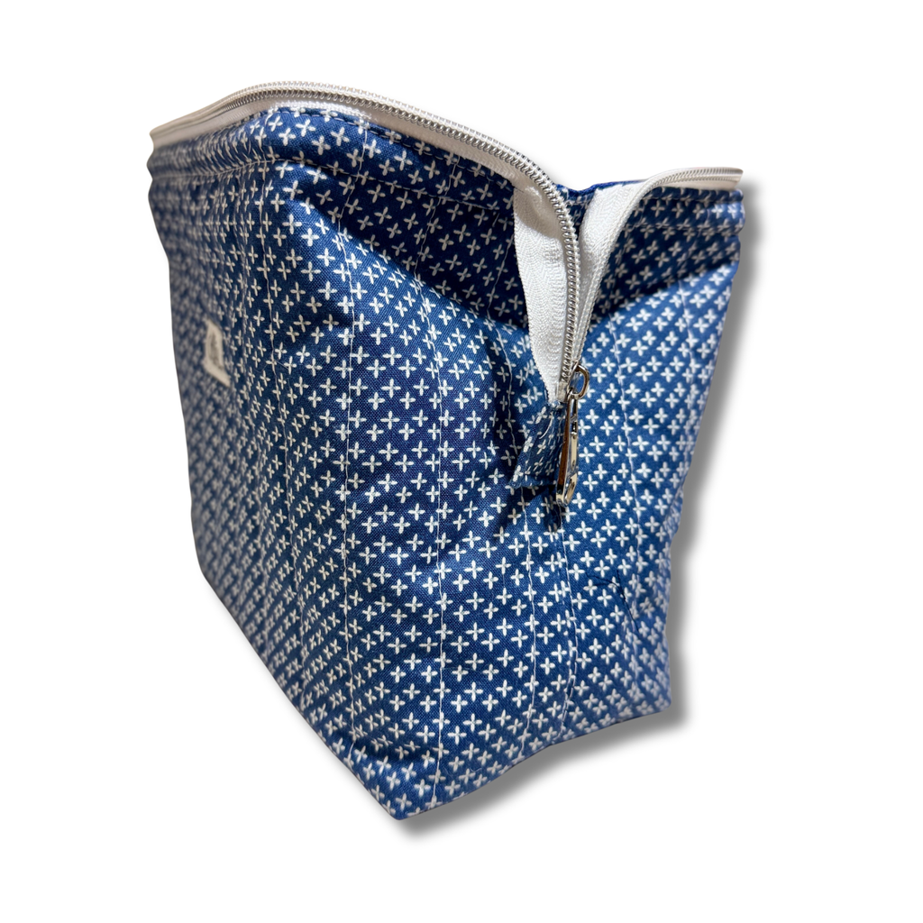 A blue and white patterned zippered pouch with a small white logo on the side, shown on a white background with a drop shadow.