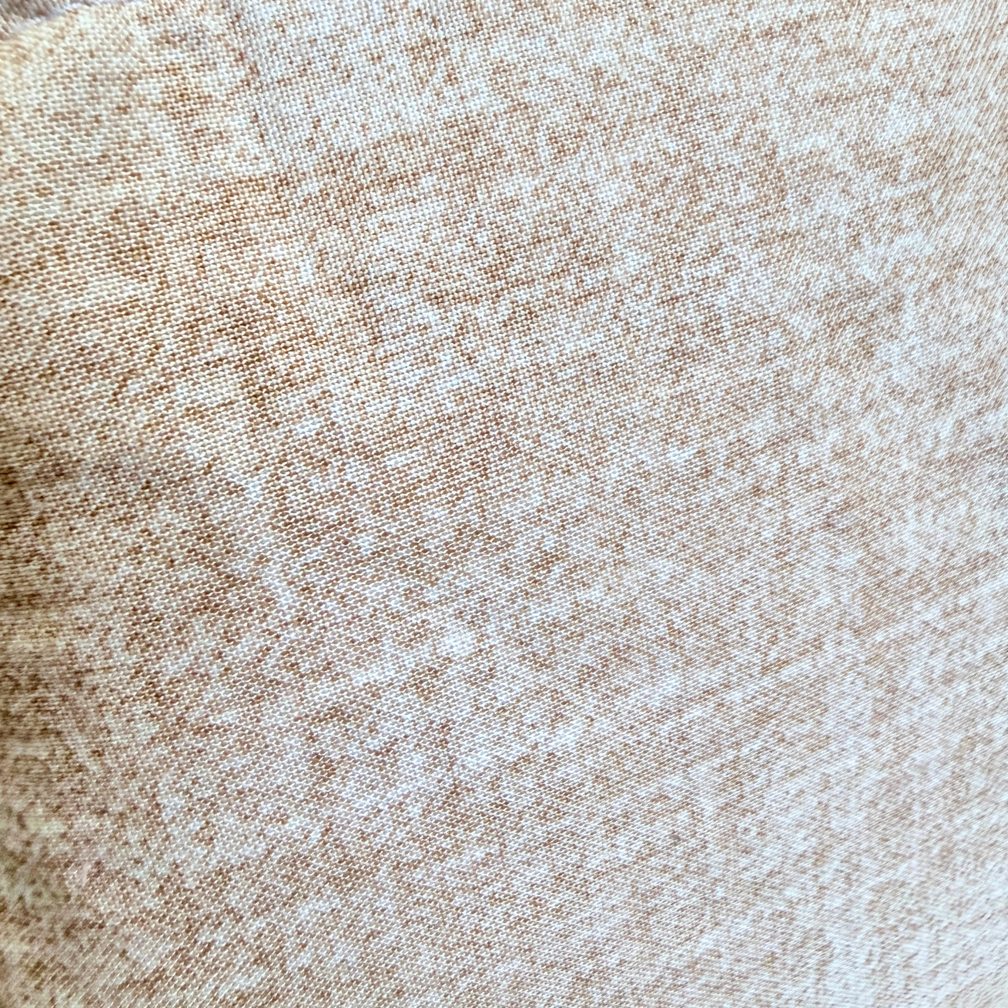 A close-up of a woven fabric texture in a heathered beige and light brown colorway.
