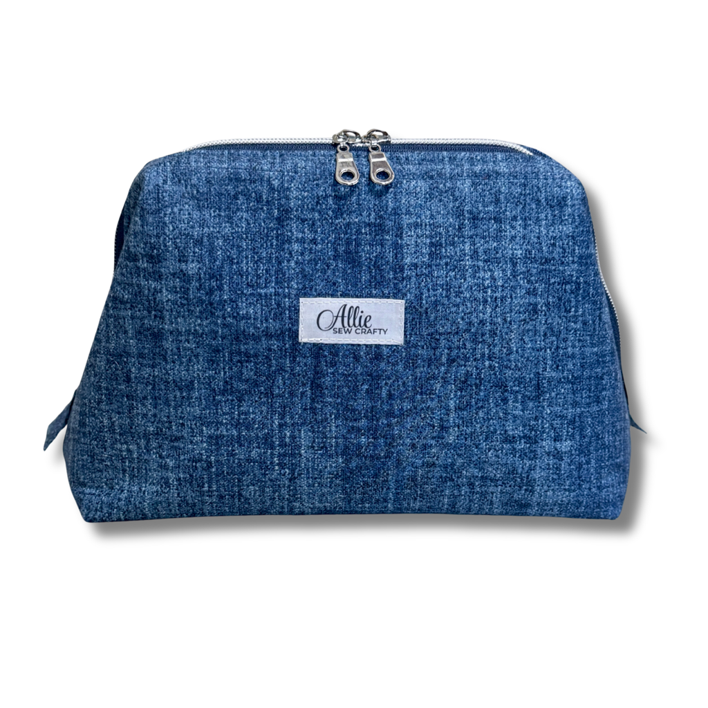 A blue denim-textured cosmetic pouch with a white brand label reading 'Allie Sew Crafty' on the front, shown against a plain white background.