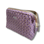 A quilted lavender cosmetic pouch with a daisy floral pattern, featuring a cream zipper and a small white label 'Allie Sew Crafty' brand label.